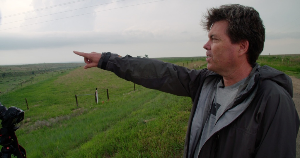 William Reid, Climatologist, pointing off to the left toward a storm.